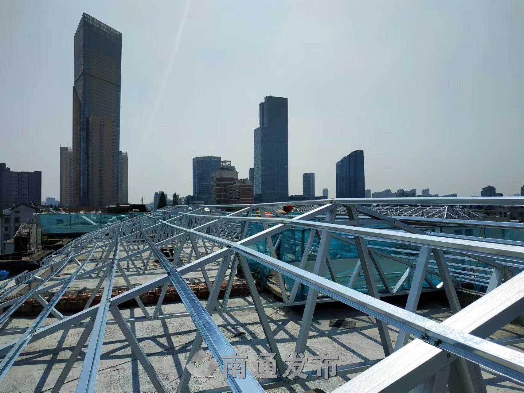 "5月16日上午,望着在小区里忙着实施屋顶"平改坡"的施工工人,家住崇川