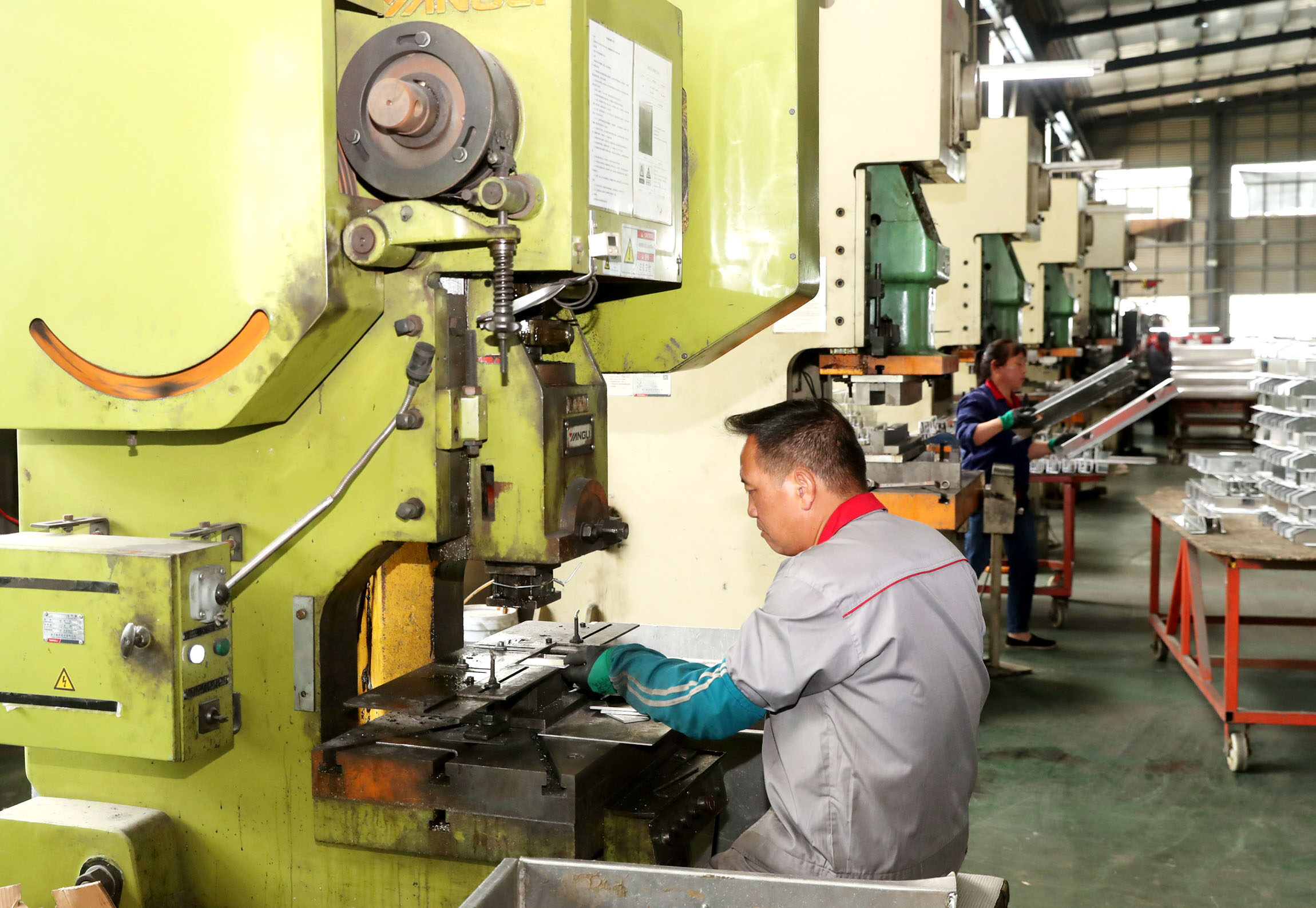 一位聋人员工在钣金下料车间钣金冲压工位工作.